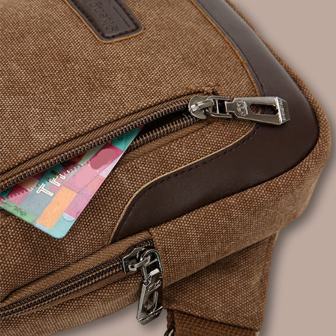 Gros plan sur la poche zippée avant de la petite sacoche en toile, pratique pour cartes et petits objets