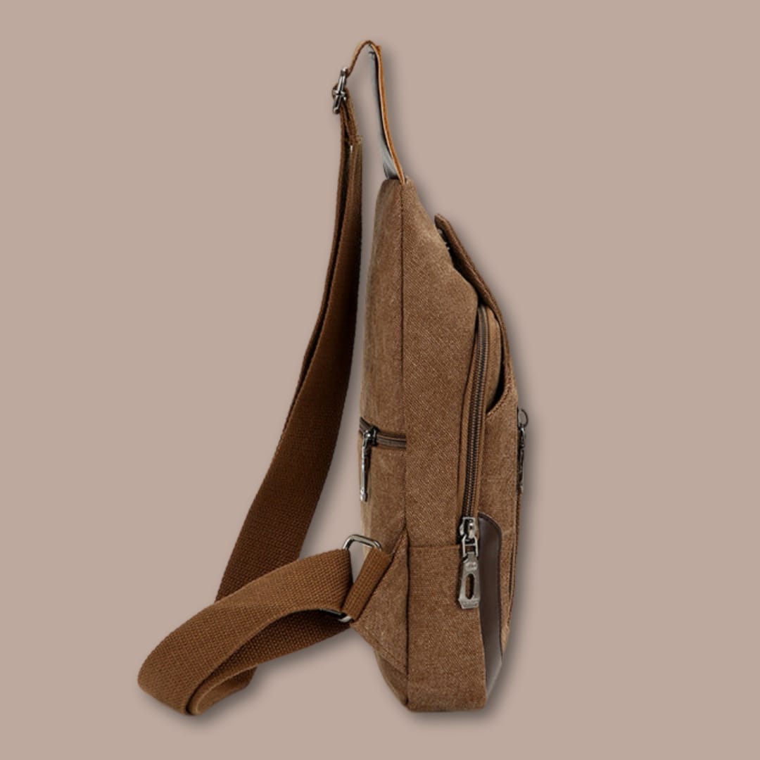 Vue de profil de la petite sacoche homme en toile marron, format fin et compact